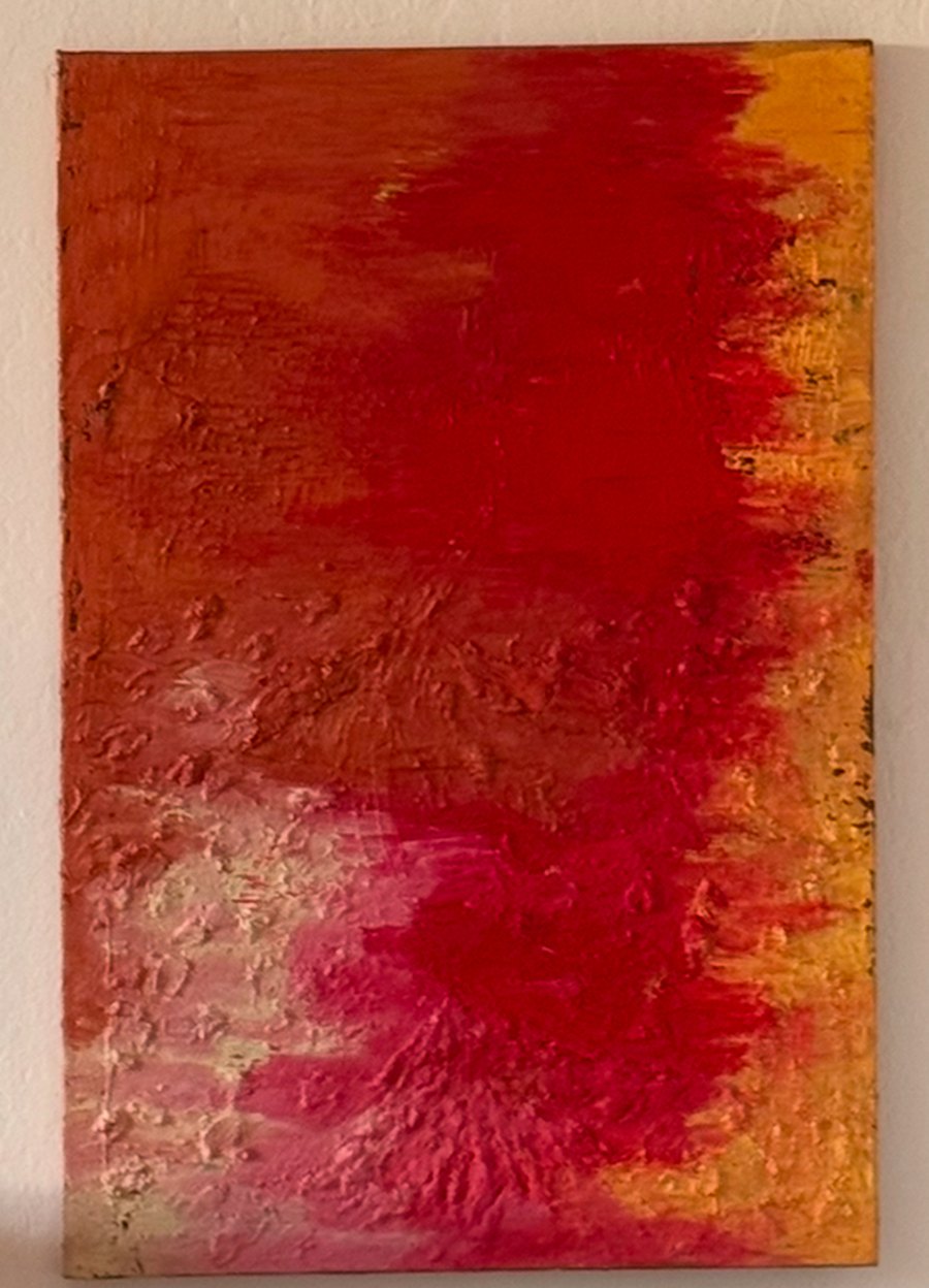 One of Inès’s paintings: red, coral and gold, on the wall at home